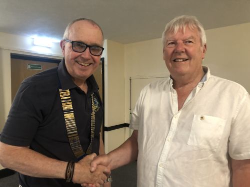 Immediate Past President Malcolm Luxton hands over the President's chain of office to Lion Peter Stonely