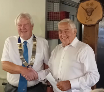 Lion Malcolm Luxton receiving the chain of office from Lion David Priestley